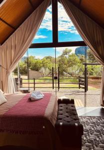 a bedroom with a bed and a large window at Kabana Harmony in Aquidauana