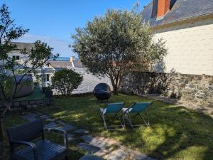two chairs and a bench in a yard at Penuel Tiny House in Granville +2 photos