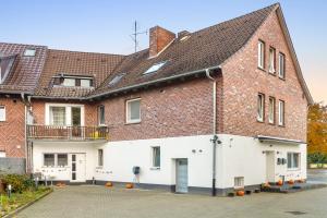 a large brick building with a white facade at Heide Ferienwohnung Nord Nr-1 in Schneverdingen