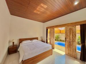 a bedroom with a bed and a large window at Tanhana Seminyak in Kerobokan