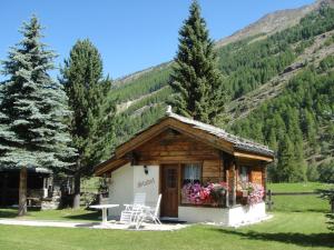 a small cabin in the mountains with a table and chairs at Chalet Stadel in Saas-Grund