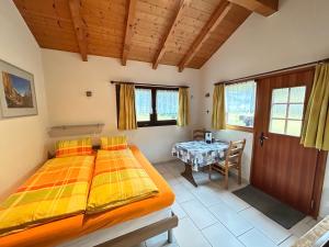 a bedroom with a large bed and a table at Chalet Stadel in Saas-Grund