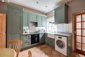 a kitchen with green cabinets and a dishwasher at Gamul Place - Quiet City Centre in Chester