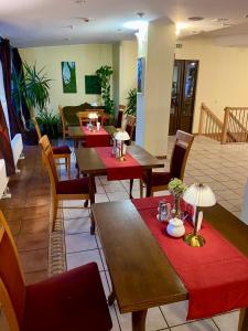 a restaurant with wooden tables and chairs with red mats at Hotel-Restaurant Smilga in Kėdainiai