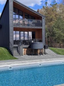 a house with a swimming pool in front of a building at Evelin in Maidan Village