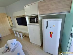 a kitchen with a white refrigerator and a microwave at Flats CTC Araras in Caldas Novas