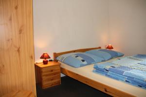 a bedroom with a bed and a nightstand with two lamps at Pension Haus Pentacon in Kurort Altenberg