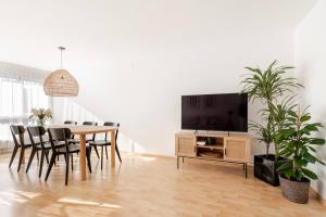 a dining room with a table with chairs and a tv at Summit View Apartment in Spiez