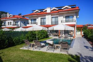 a house with chairs and a swimming pool in the yard at Villa Lidya in Dalyan