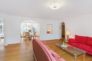 ein Wohnzimmer mit einem roten Sofa und einem Tisch in der Unterkunft Hotel Mozart in Rorschach + 24 Fotos