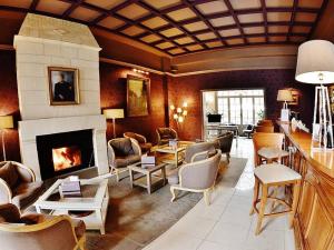a living room with a fireplace and a living room with chairs at Domaine de Joinville & Spa in Eu