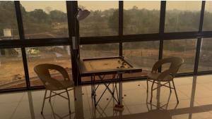 a ping pong table with two chairs in front of a window at The Sixth Abode Farms 5 BHK Villa with Swimming Pool, Turf, Lawn & Indoor Games- Khopoli in Jambhulpāda