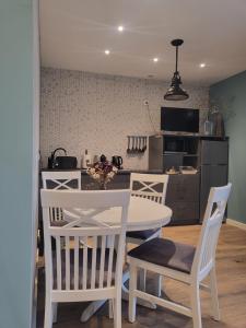 a kitchen and dining room with a white table and chairs at Apartament Milena in Kruszyn