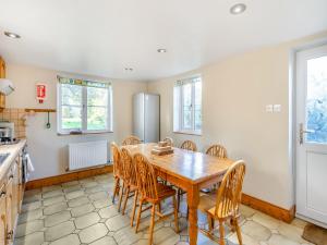 a kitchen with a wooden table and chairs at Prosperous Villa in Puncknowle