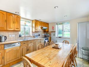 a kitchen with wooden cabinets and a wooden table at Prosperous Villa in Puncknowle