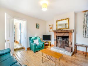 a living room with a couch and a fireplace at Prosperous Villa in Puncknowle
