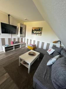 a living room with a couch and a table at Ferienwohnung Wildblume in Fehmarn