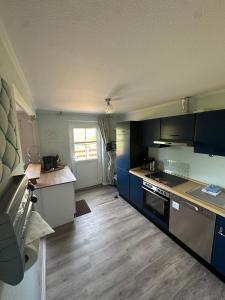 a kitchen with blue cabinets and a counter top at Ferienwohnung Wildblume in Fehmarn +3 photos