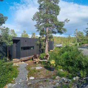 a house in the woods with a tree at Modern Cabin At Blefjell in Svene