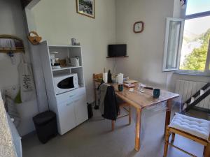 a small kitchen with a table and a microwave at Appart situé au sein d'une résidence à Barèges pour 4 à 6 personnes, 1 chambre, 1 mezzanine in Barèges +13 photos
