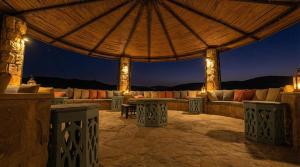 an outdoor patio with couches and a large umbrella at Golden Heights Resort in Al Ḩanī