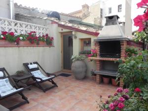 an outdoor patio with two chairs and a fireplace at la buhardilla de mi casa in Alcañiz