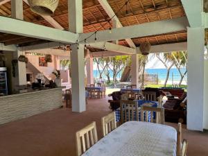 a dining room with a table and chairs and the ocean at Le ZANATANY BEACH in Tamatave