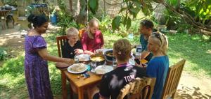 a group of people sitting around a table eating at Mango Villa - Panama Near Arugam Bay in Panama +45 photos