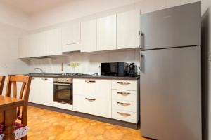 a kitchen with white cabinets and a refrigerator at Residenza Santa Rita in Novara