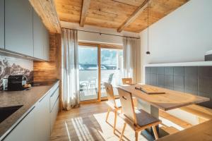 a kitchen with a wooden table and chairs at Kuenzerhof Apartments in Braies