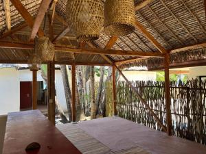 a porch with a wooden table and straw roof at Le ZANATANY BEACH in Tamatave