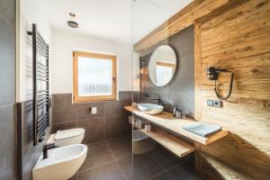 a bathroom with a sink and a mirror at Kuenzerhof Apartments in Braies +32 photos