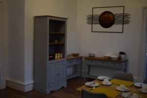 a dining room with a cabinet and a table at Woodlyn Guest House in Gatehouse of Fleet