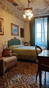 a bedroom with a bed and a couch and a table at DIMORA della TORRE a due passi dal mare in Sestri Levante
