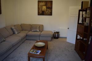 a living room with a couch and a coffee table at Woodlyn Guest House in Gatehouse of Fleet