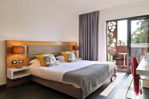 a bedroom with a large bed and a large window at Hôtel San Lucianu in Moriani Plage +49 photos