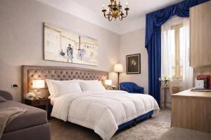 a bedroom with a large white bed and blue curtains at Hotel Ristorante Ala d'Oro in Lugo