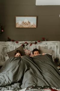 a man and woman laying in bed under a blanket at The Klinck House in Collingwood