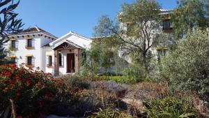 a white house with a garden in front of it at Loma la Parra in Valle de Abdalagís