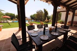 a table with plates and wine glasses on a patio at Loma la Parra in Valle de Abdalagís