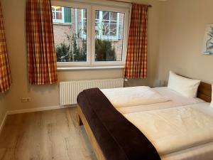 a bedroom with two beds and a window at Haus Seeschwalbe - Wohnung 07 in Spiekeroog