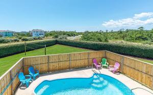 a swimming pool with chairs and a fence at Puppy Love - Corolla, Villages at Ocean Hill, Pool, Hot Tub, Nearby Amenities, Lighthouse, Pets OK in Corolla