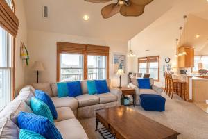 a living room with a couch and a table at Puppy Love - Corolla, Villages at Ocean Hill, Pool, Hot Tub, Nearby Amenities, Lighthouse, Pets OK in Corolla