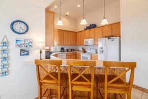a kitchen with wooden cabinets and a white refrigerator at Puppy Love - Corolla, Villages at Ocean Hill, Pool, Hot Tub, Nearby Amenities, Lighthouse, Pets OK in Corolla +68 photos