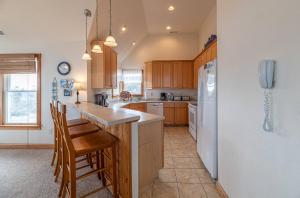 a kitchen with wooden cabinets and a white refrigerator at Puppy Love - Corolla, Villages at Ocean Hill, Pool, Hot Tub, Nearby Amenities, Lighthouse, Pets OK in Corolla
