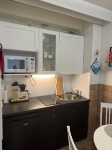 a kitchen with white cabinets and a sink at Kylpylä-Hotelli 364 in Ikaalinen