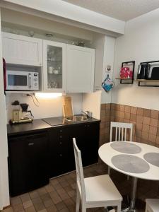 a small kitchen with a table and a microwave at Kylpylä-Hotelli 364 in Ikaalinen