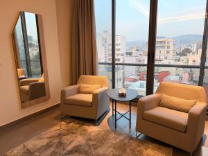 a room with two chairs and a table and windows at Unit For Living in Beirut