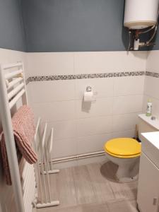 a bathroom with a toilet with a yellow lid at Cabine de la plage 2 in Fécamp