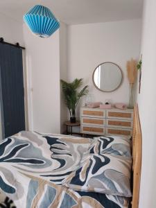 a bedroom with a bed with a mirror and a dresser at Cabine de la plage 2 in Fécamp +12 photos
